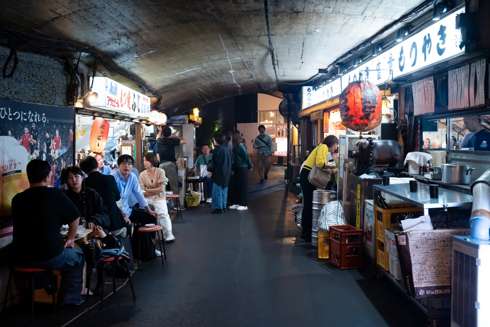 有楽町の高架下。左手に、もつ焼きふじの看板が見える夜の通り